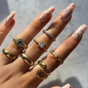 Close-up of hand wearing 18K gold plated stainless steel irregular rings set with green gems