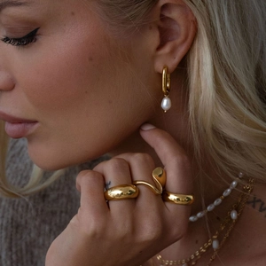 Close-up of 18K gold plated irregular rings and pearl necklace on female model