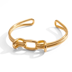 Dettaglio macro del bracciale rigido in acciaio inossidabile placcato oro 18k con nodo