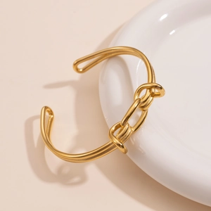 Dettaglio di un bracciale aperto in acciaio inossidabile placcato oro 18k con maglia