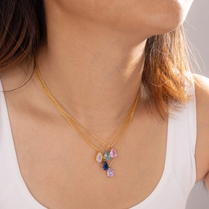 Dettaglio di collane in acciaio inossidabile placcate oro 18k con pietre portafortuna a goccia