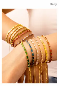 Detail of multi-colored rectangular zircon bracelets on wrist with adjustable gold chains
