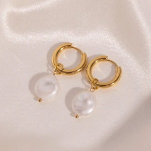 Detailed close-up of 18K gold-plated stainless steel earrings with baroque pearls on silk