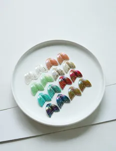Detailed view of colorful iridescent fishtail resin charms for DIY jewelry making
