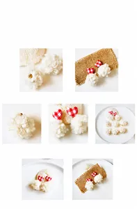 Close-up of white plush ball earrings with red checkered heart fabric and gold beads
