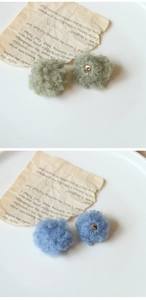 Dettaglio di ciondoli a pompon in peluche con cristalli scintillanti per gioielli fai-da-te