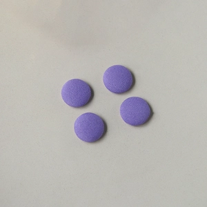 Nahaufnahme von vier runden violetten Stoffknöpfen mit feiner Köperstruktur für DIY