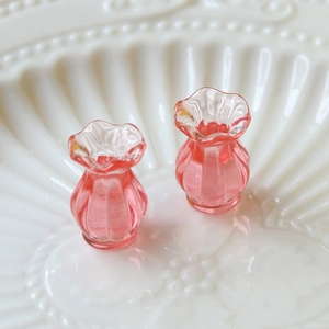 Macro shot of pink miniature glass-like vases with wavy rims and vertical textures