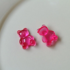 Detail macro view of translucent jelly gummy bear charms in vibrant pink resin