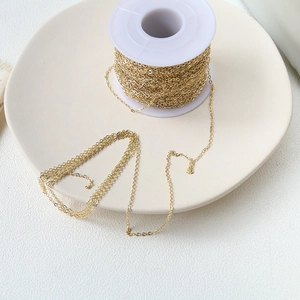 Macro detail of gold-plated O-chain DIY jewelry link on a white spool for crafting