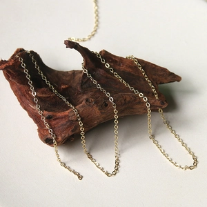 Minimalist gold plated oval link chain necklace displayed on dark natural driftwood