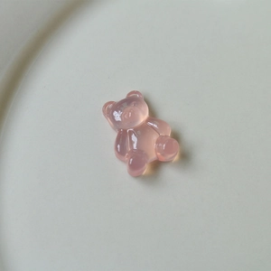 Close-up of translucent pink gummy bear charm in UV resin material for DIY jewelry crafts