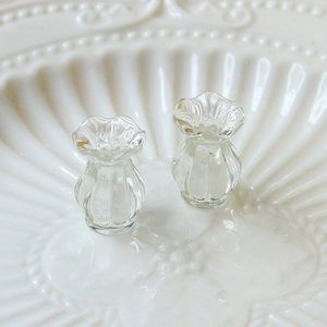 Macro shot of miniature clear glass vases with ruffled edges and vertical ribbing details
