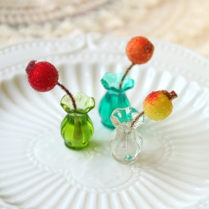 Miniature glass fluted vases set with frosted berry stems on a white decorative plate