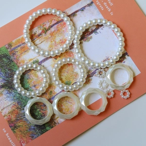 Detail of DIY pearl bead rings and faceted cream resin rings on an artistic card