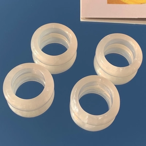 Minimalist cream white resin rings set on blue mirror background with reflection