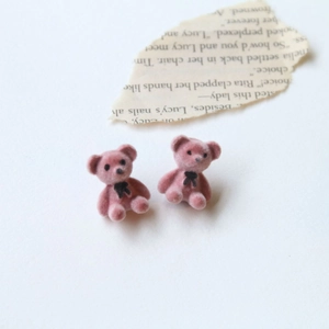 Vue macro de mignons ours floqués roses avec nœuds papillon noirs sur fond blanc