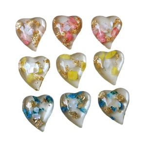 DIY heart-shaped resin charms with gold foil and dried flowers in pink yellow blue
