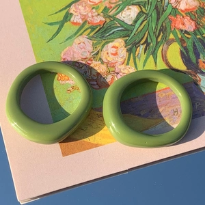 Anelli irregolari in resina verde matcha dal design minimalista su carta d'arte