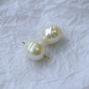 Perle d'acqua dolce ovali barocche con inserti in metallo dorato su sfondo bianco