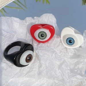 Close-up of heart-shaped resin rings featuring realistic blue, green and brown eyeballs
