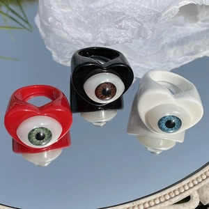 Macro view of chunky resin rings featuring realistic glass eye inlays in Y2K style