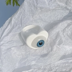 Close-up of a white resin ring featuring a blue heart-shaped eye for DIY jewelry making