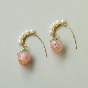 Detail von Tulpen-Ohrringen mit rosa Harzblättern, Golddraht und weißen Perlen