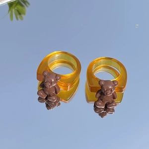 Primer plano de anillos de oso de resina ámbar que reflejan el cielo azul en espejo