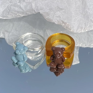 Vista detallada de anillos de oso de resina en azul transparente y marrón ámbar