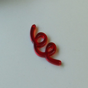 Macro-detail van een rode doorschijnende acryl spiraalvormige hanger voor DIY-sieraden