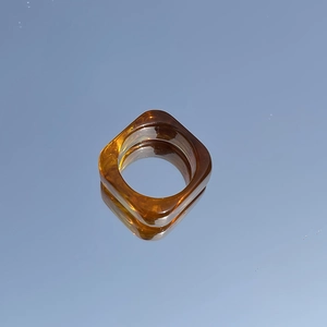 Macro view of square amber resin ring with tortoise shell patterns on reflective surface