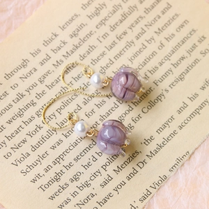 Detalle de pendientes de lirio de los valles en vidrio púrpura con perlas vintage