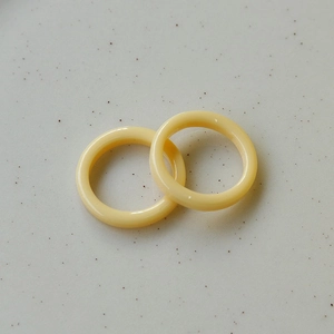 Detailed view of interconnected minimalist cream resin rings with a smooth polished finish