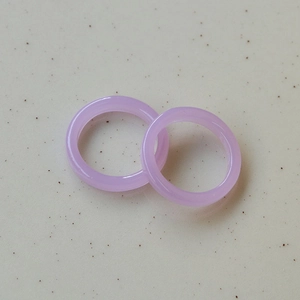 Minimalist summer style translucent purple resin rings set on white stone surface