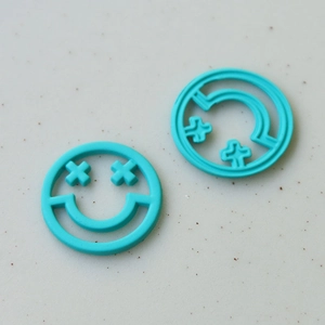 Dettaglio di ciondoli a forma di faccina sorridente blu per accessori per capelli DIY