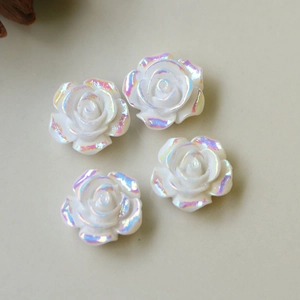 Detailansicht von vier irisierenden weißen Harzrosen für DIY-Schmuck und Handwerk