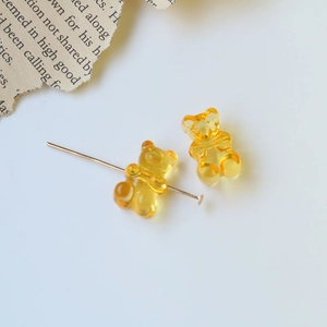 Macro shot of translucent yellow gummy bear resin charm with metal pin for DIY jewelry making