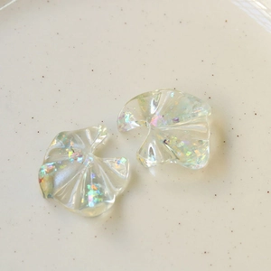 Pearlescent fan-shaped resin jewelry charms with colorful laser sequins on ceramic plate