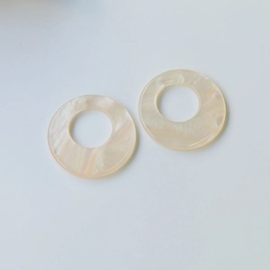 Detailed view of round iridescent resin pendants with pearlescent marble texture