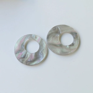 Macro shot of circular marble texture resin charms for DIY jewelry and earrings