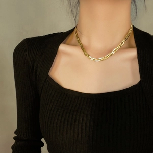 Three-layer gold braided snake chain necklace styled on model with black square neck top