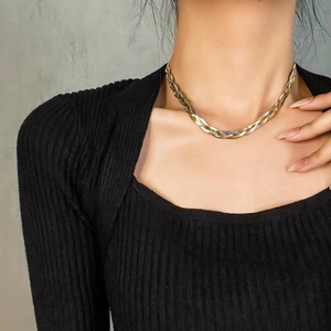 Detailopname van een driekleurige gevlochten metalen choker bij een model