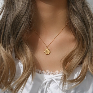 Dettaglio della collana placcata oro 18K con ciondolo a moneta vintage con rilievo floreale