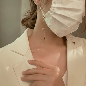 Golden heart pendant chain for masks and glasses shown on a model with white suit