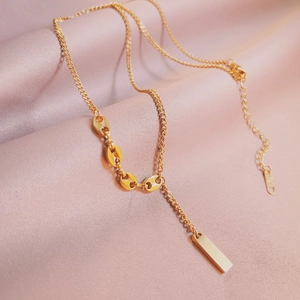 Elegant gold Y-shaped necklace with coffee bean links and vertical bar pendant