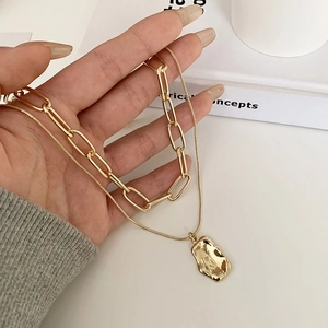 Double layered gold necklace with paperclip chain and irregular square pendant detail