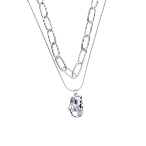Double-layered silver necklace featuring a paperclip chain and irregular lava pendant