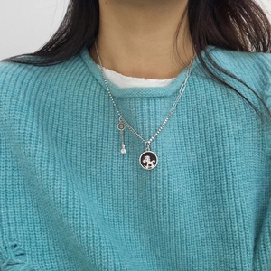 Collier cheval à bascule en argent avec chaîne à maillons et pendentifs dollar sur tricot