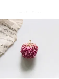 Macro detail of deep pink dried flower pendant with a gold metal ring for DIY jewelry